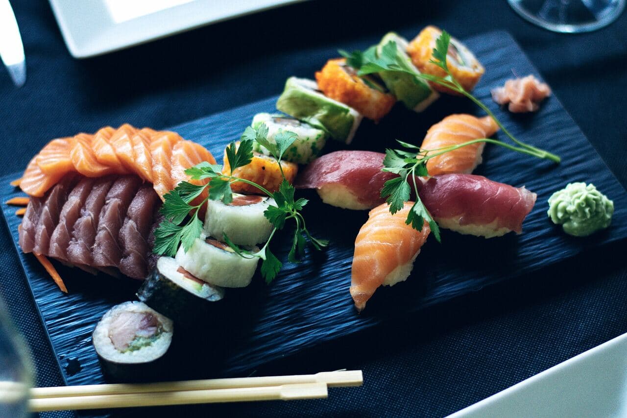 Fat med blandad sushi: nigiri, maki och sashimi